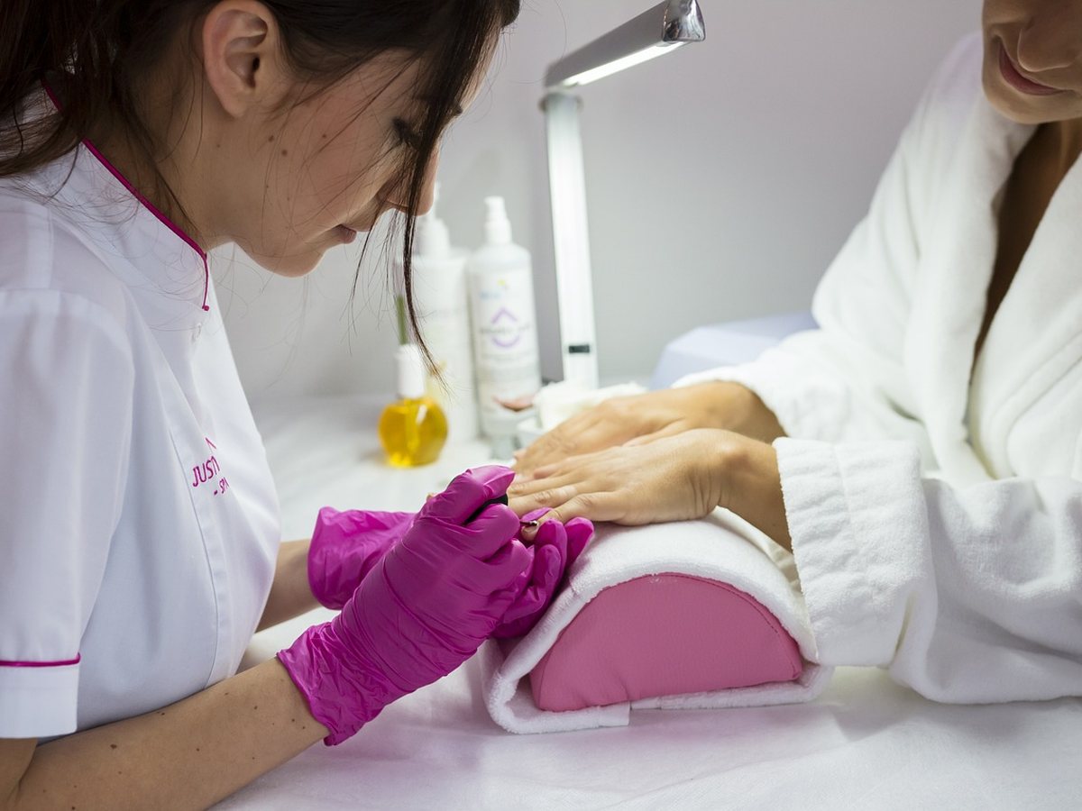Esthéticienne réalisant une manucure en institut